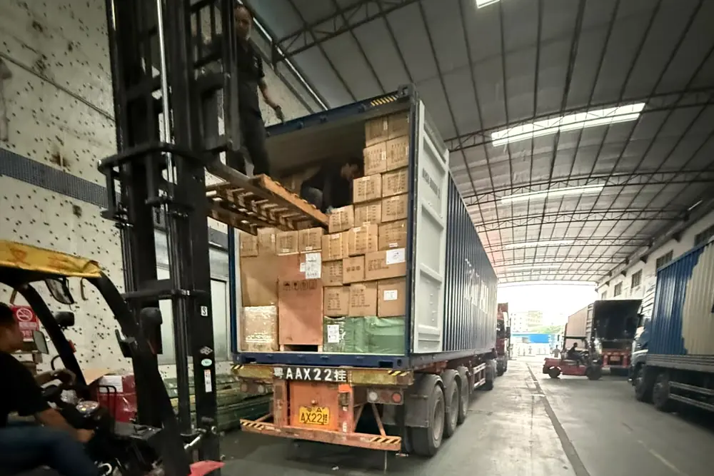 Forklift lifting a pallet of cartons into a container at the Guangzhou loading bay